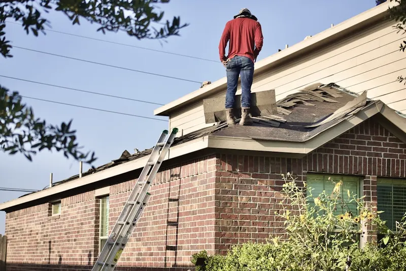 Professional roofer working on a residential roof in Shelton